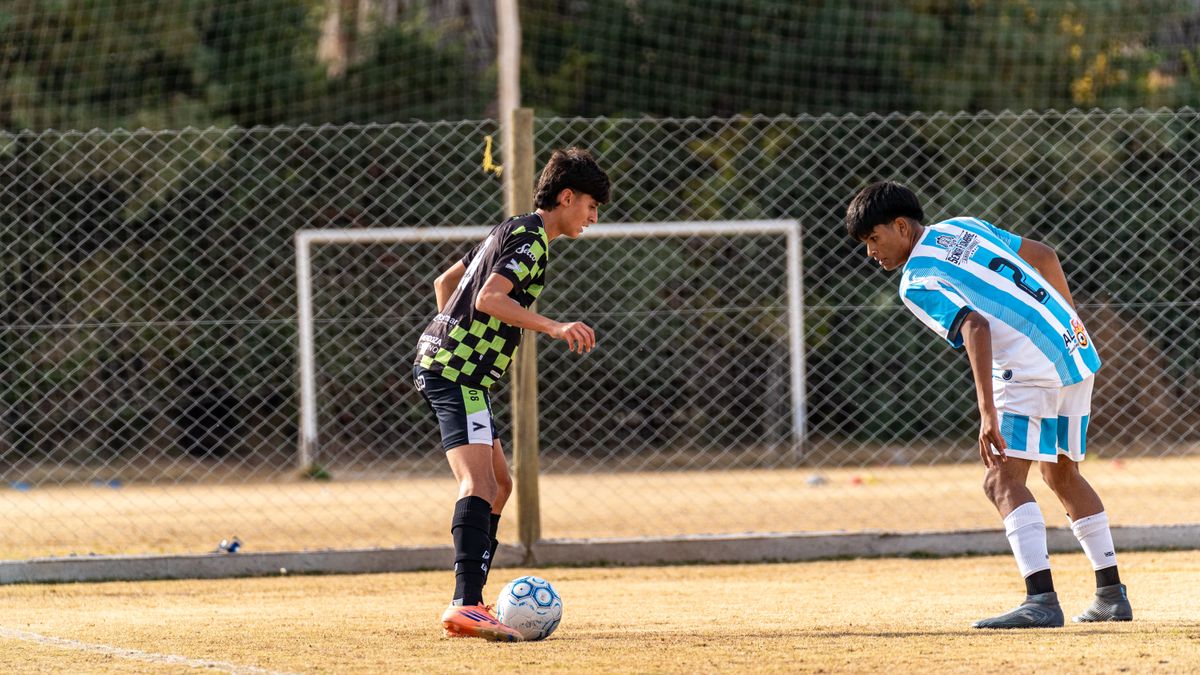 Young athletes engaged in a competitive soccer match outdoors on a sunny day. Young athletes engaged in a competitive soccer match outdoors on a sunny day.