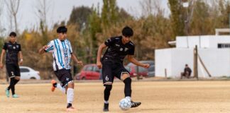 Young players in a local football match, showcasing skill and teamwork.