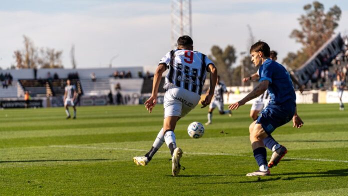 Players in action on the soccer field during an outdoor match under the bright sun. Players in action on the soccer field during an outdoor match under the bright sun.