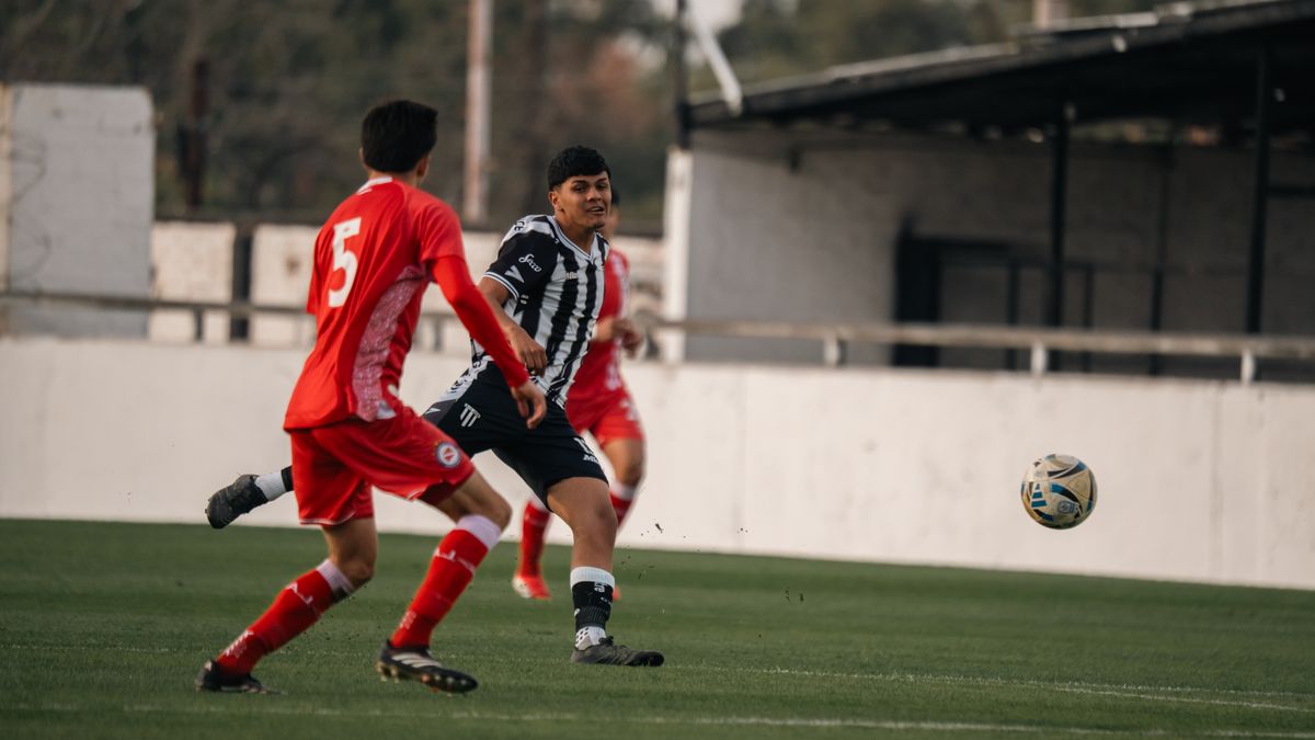 Two soccer players in action on the field, competing intensely during a match. Two soccer players in action on the field, competing intensely during a match.