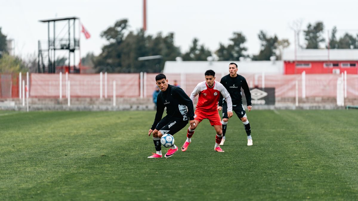 Dynamic soccer match with players in motion on a green outdoor field.