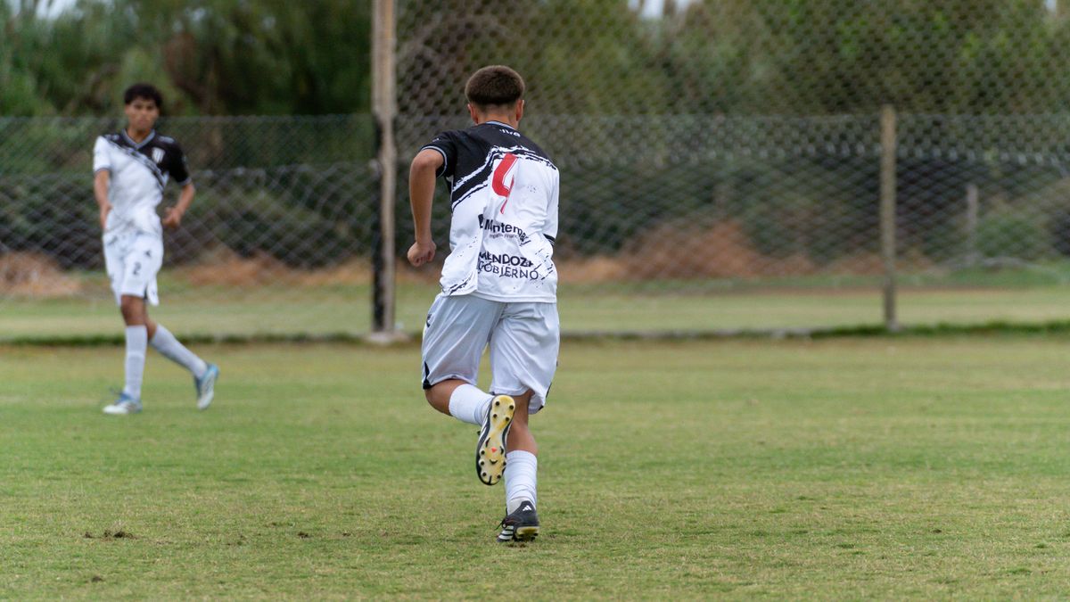 Teenagers playing soccer outdoors, showcasing teamwork and athleticism on a grassy field.
