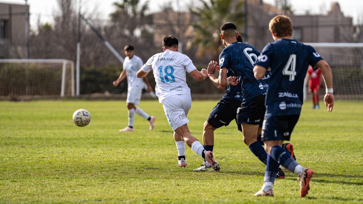 Football players in action on a sunny day, showcasing teamwork and competition.