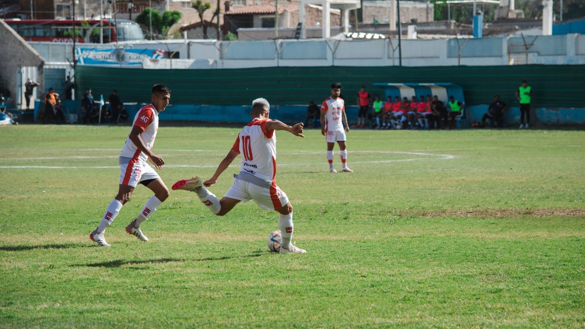 Intense soccer game in Mina, Mendoza, Argentina showcasing teamwork and action on a sunny day.