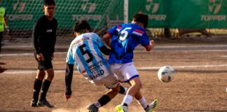 Intense soccer match action with two players competing for the ball on an outdoor field.