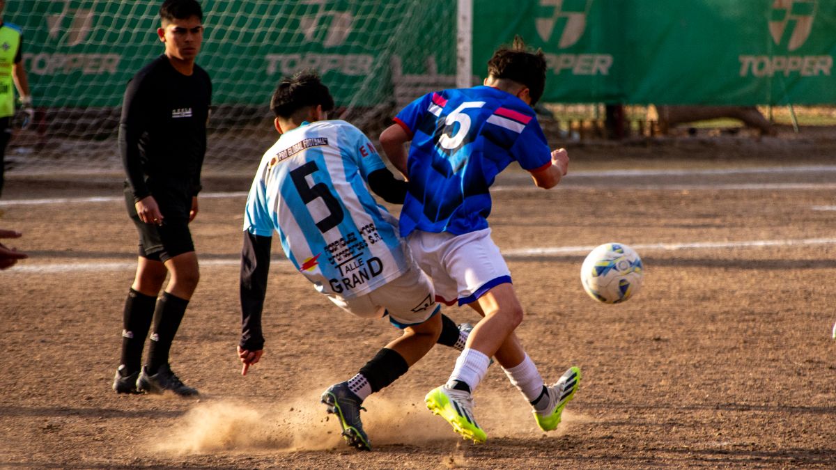 Intense soccer match action with two players competing for the ball on an outdoor field. Intense soccer match action with two players competing for the ball on an outdoor field.