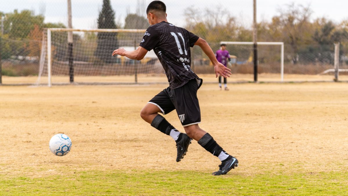 Soccer player dribbling the ball during a match on an outdoor field. Soccer player dribbling the ball during a match on an outdoor field.