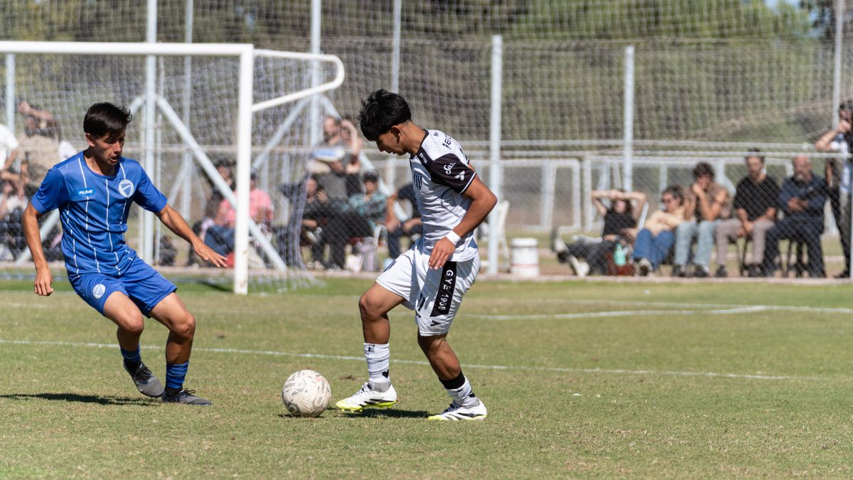 Young athletes compete passionately on the soccer field during a sunny outdoor match.