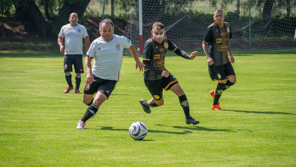 Action-packed amateur soccer match scene with adult players in sportswear on a sunny day.
