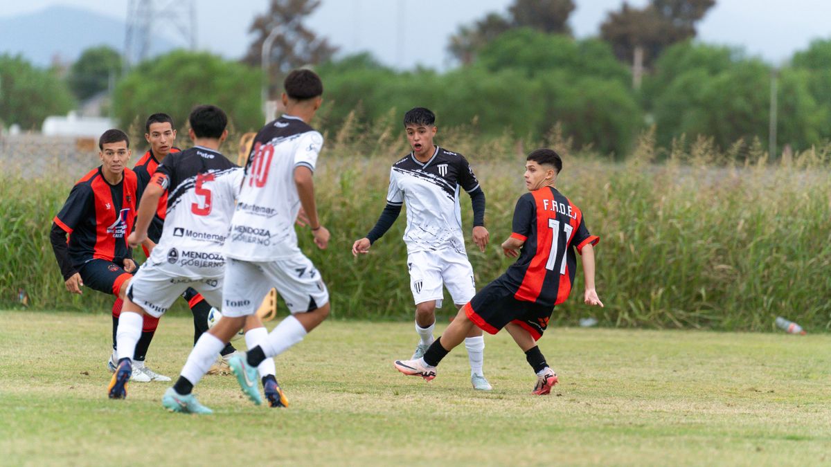 Dynamic scene of teenage soccer players in competitive outdoor match.