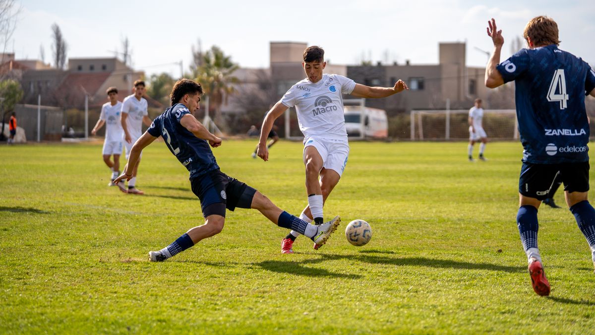 Players engage in a challenging football match on a sunny day.