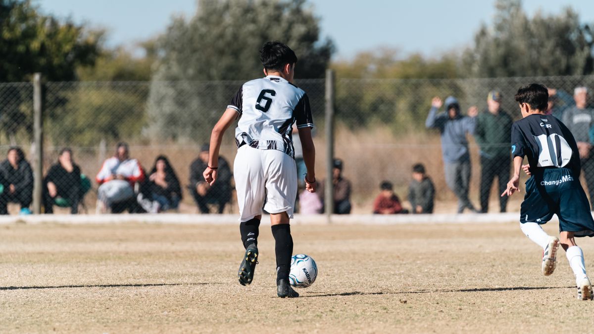Young soccer players in action during a sunny outdoor match on a grassy field.