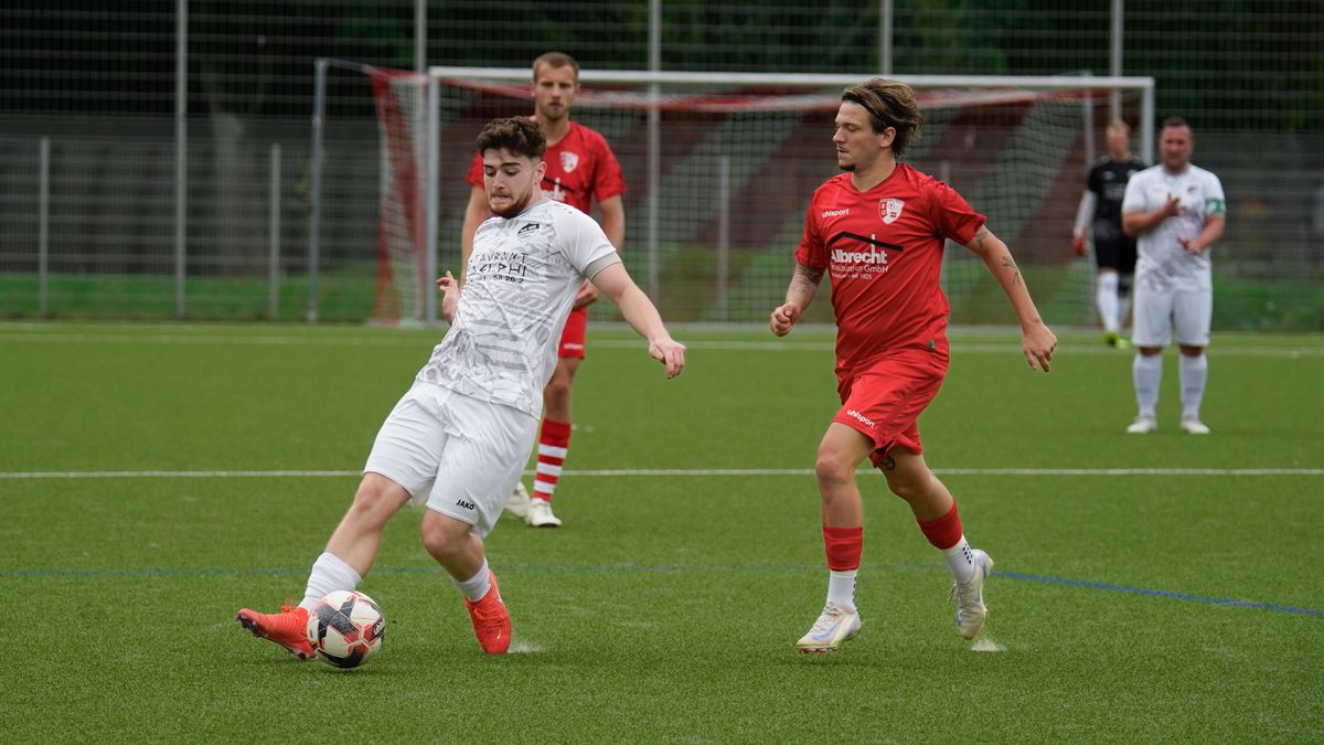 Football players in action during a match on a grassy sports field.