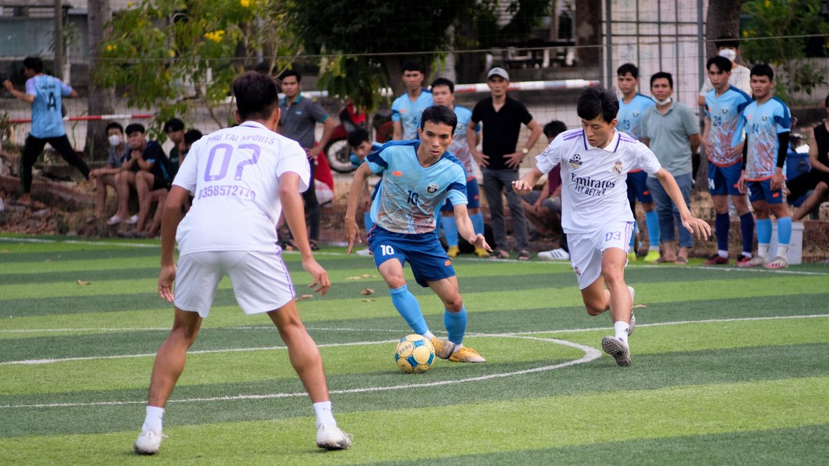 Players energetically compete in a local soccer match while spectators watch intently.