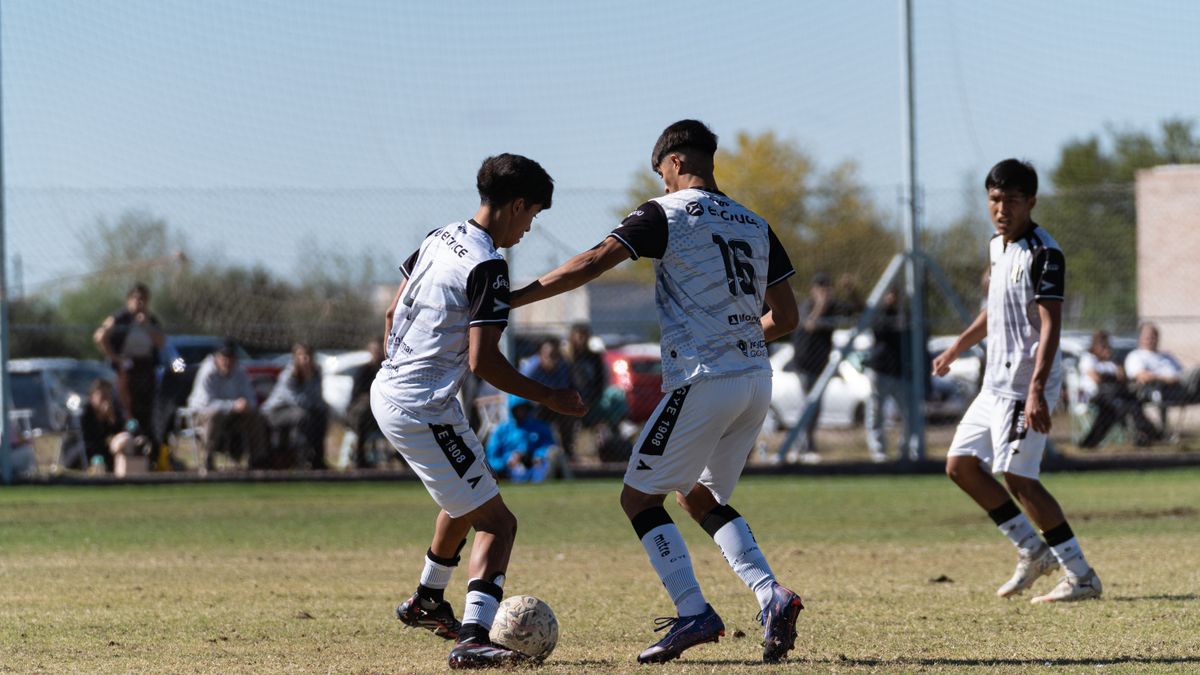 Young soccer players in action on the field during a daytime match.