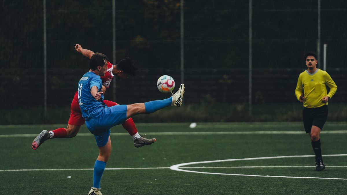 Action-packed soccer game showing two athletes competing for the ball on the field.