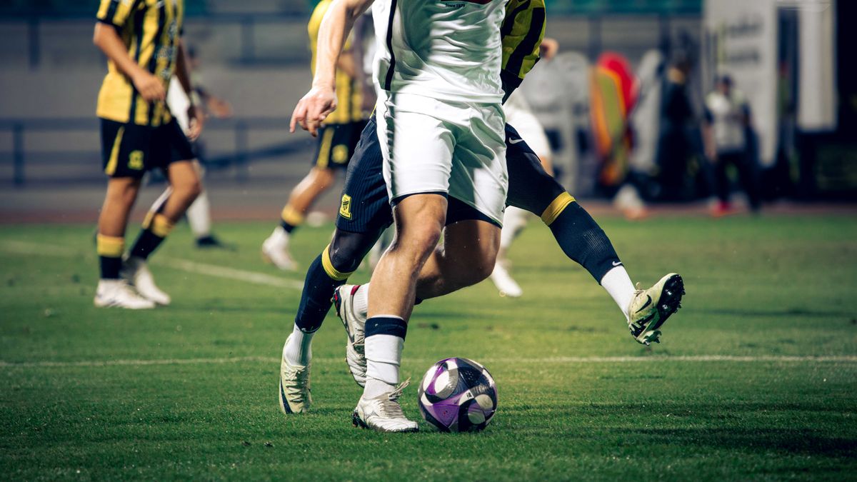 Close-up of soccer players in action during a match at an outdoor stadium. Close-up of soccer players in action during a match at an outdoor stadium.