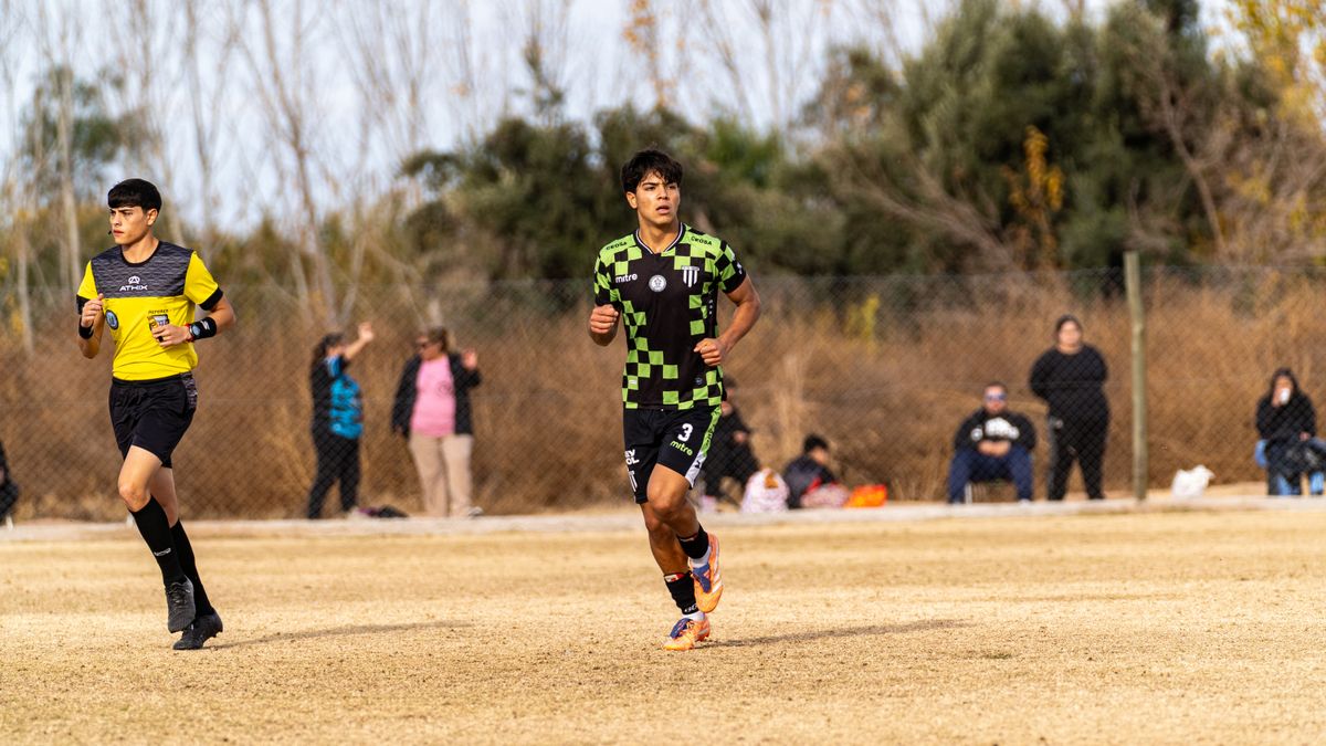 A competitive outdoor soccer match with young athletes in action on a grassy field.