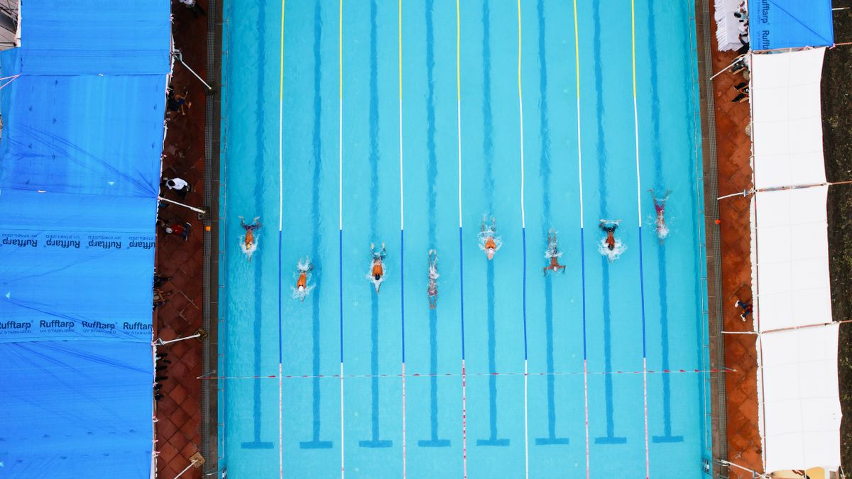 Overhead shot of swimmers racing in an outdoor pool in Indore, India.