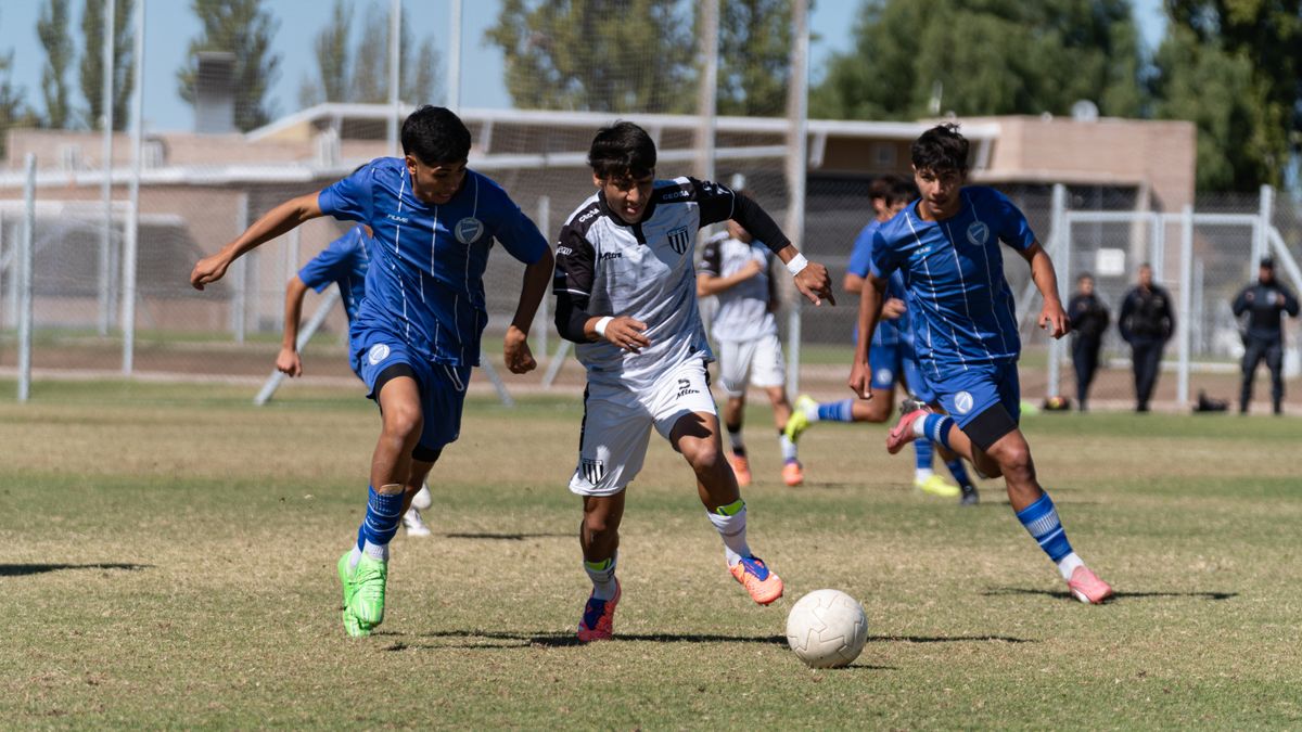 Players compete fiercely in a vibrant soccer match on a sunny day.