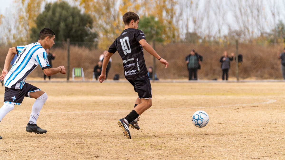 Two young soccer players in action during a competitive outdoor match.