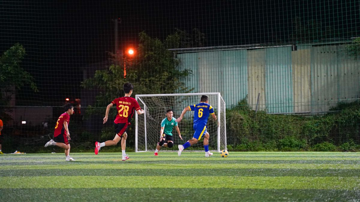 Youth soccer players in action on a lit field at night, showcasing teamwork and energy.
