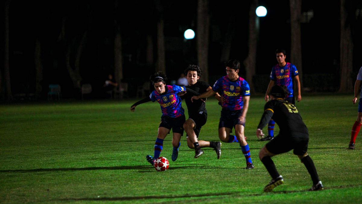 Action-packed night soccer match with players competing under field lights.