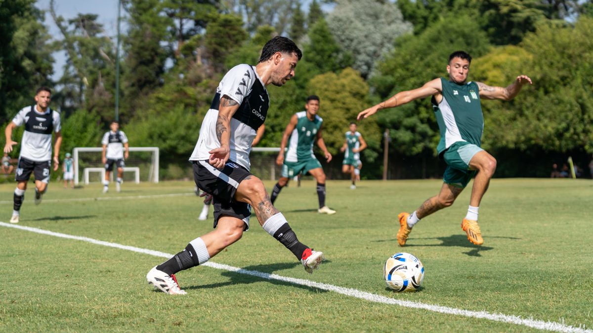 Action-packed soccer game with players competing on an outdoor field in bright daylight.