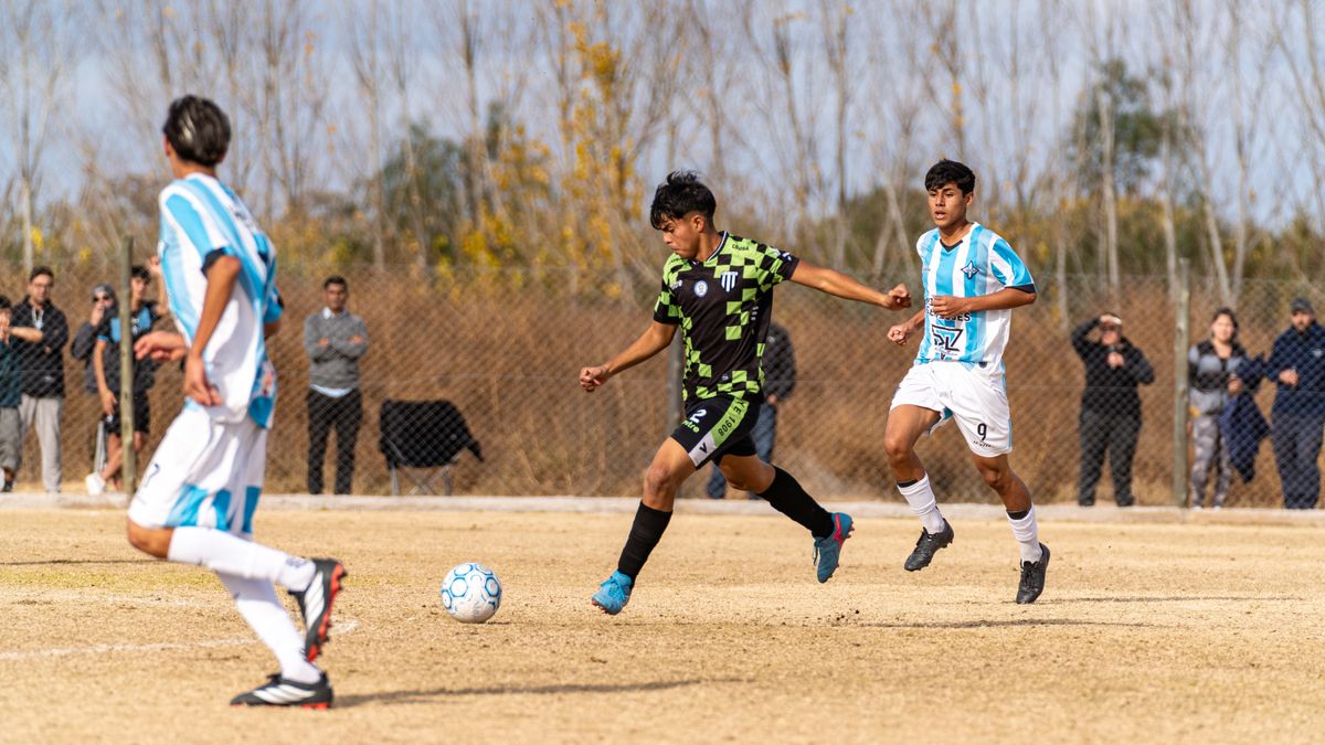 Exciting action shot of a youth soccer game on a sunny day with players in motion and a lively crowd. Exciting action shot of a youth soccer game on a sunny day with players in motion and a lively crowd.