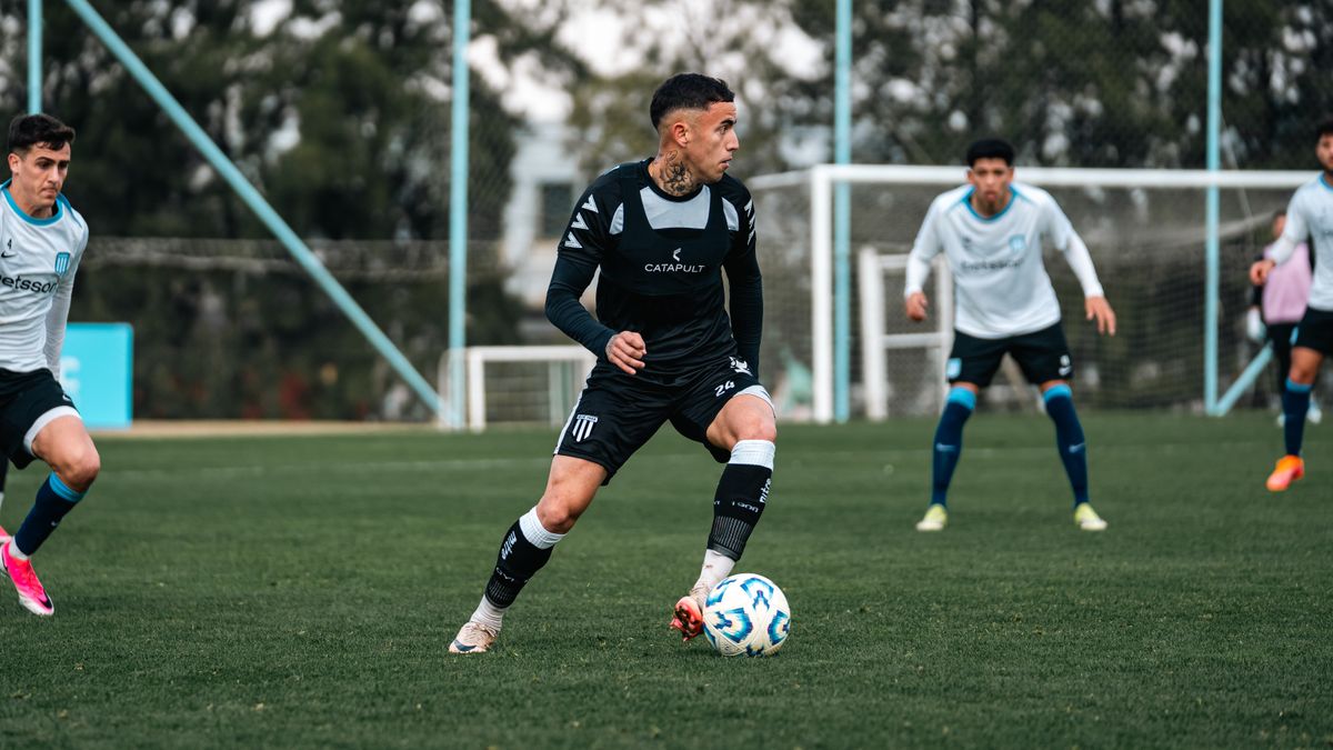 Soccer players in action during a competitive match on a grass field.