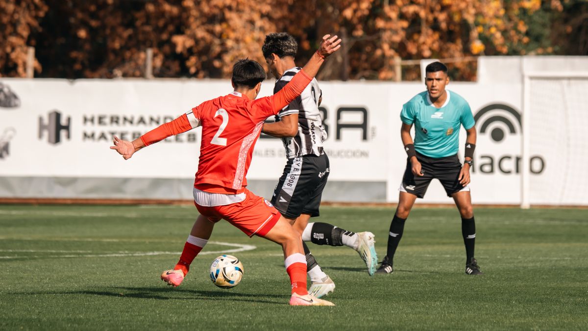 Close-up action in a competitive soccer match outdoors with players and referee in focus.
