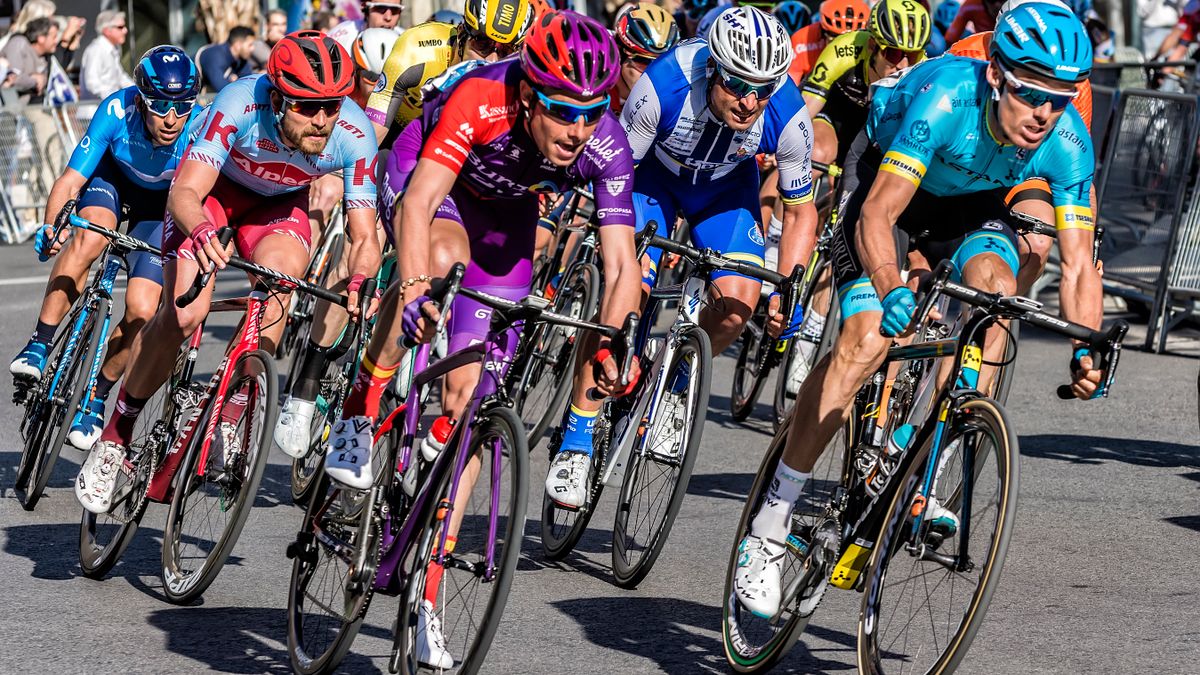 Competitive cyclists in vibrant gear race through Alicante streets, showcasing speed and athleticism. Competitive cyclists in vibrant gear race through Alicante streets, showcasing speed and athleticism.