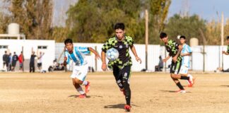 Dynamic action shot of teenagers playing soccer on a sunny field.