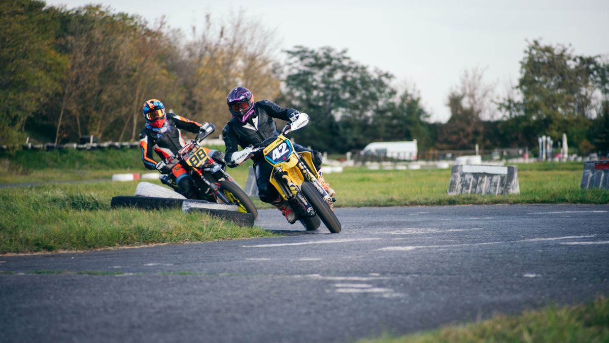 Exciting image of two motorcyclists racing on an outdoor track, capturing speed and motion.