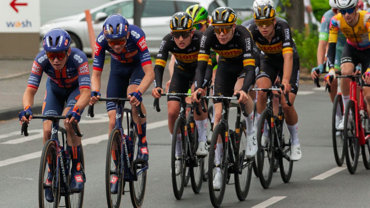 Group of cyclists racing on city streets during a competitive cycling event.