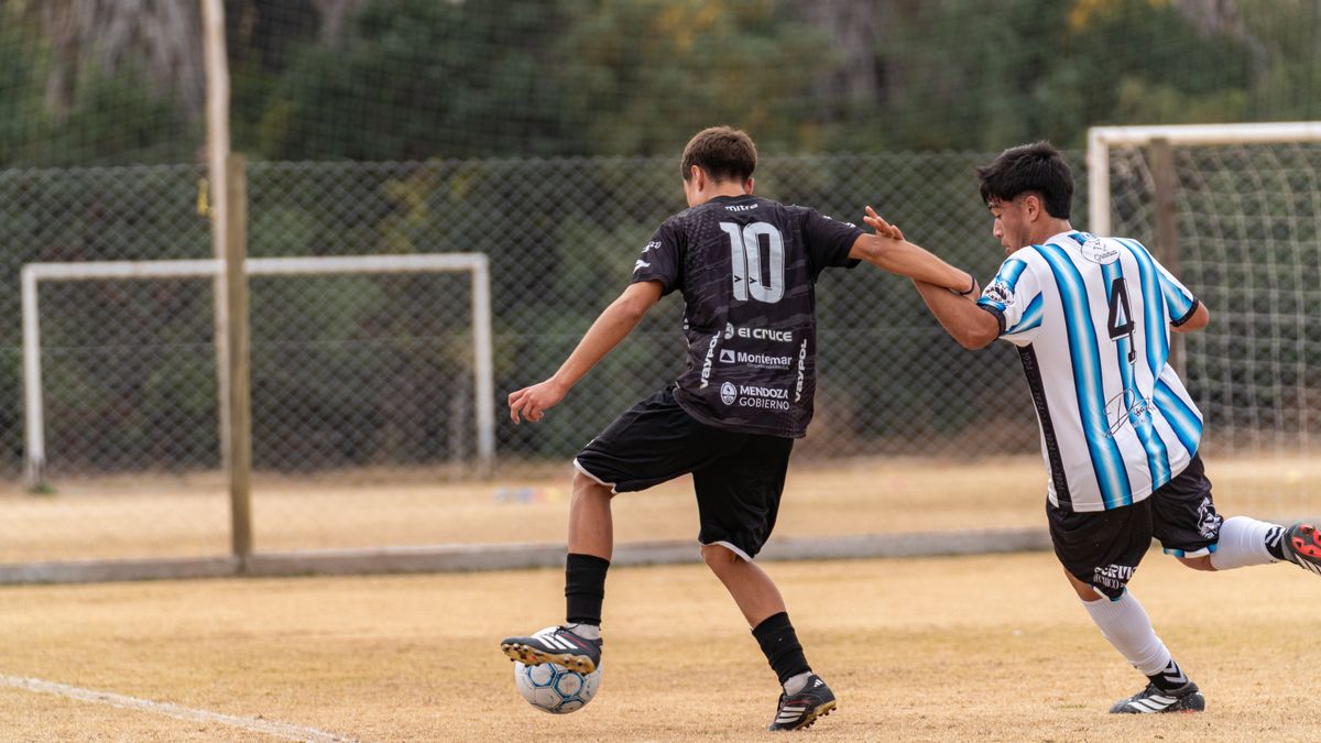 Two young men competing in an outdoor soccer match, showcasing athleticism and teamwork.