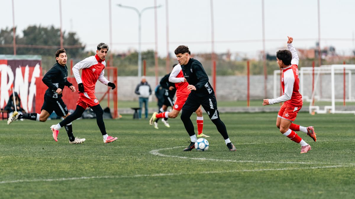 Young soccer players in action during a competitive match on a grass field.
