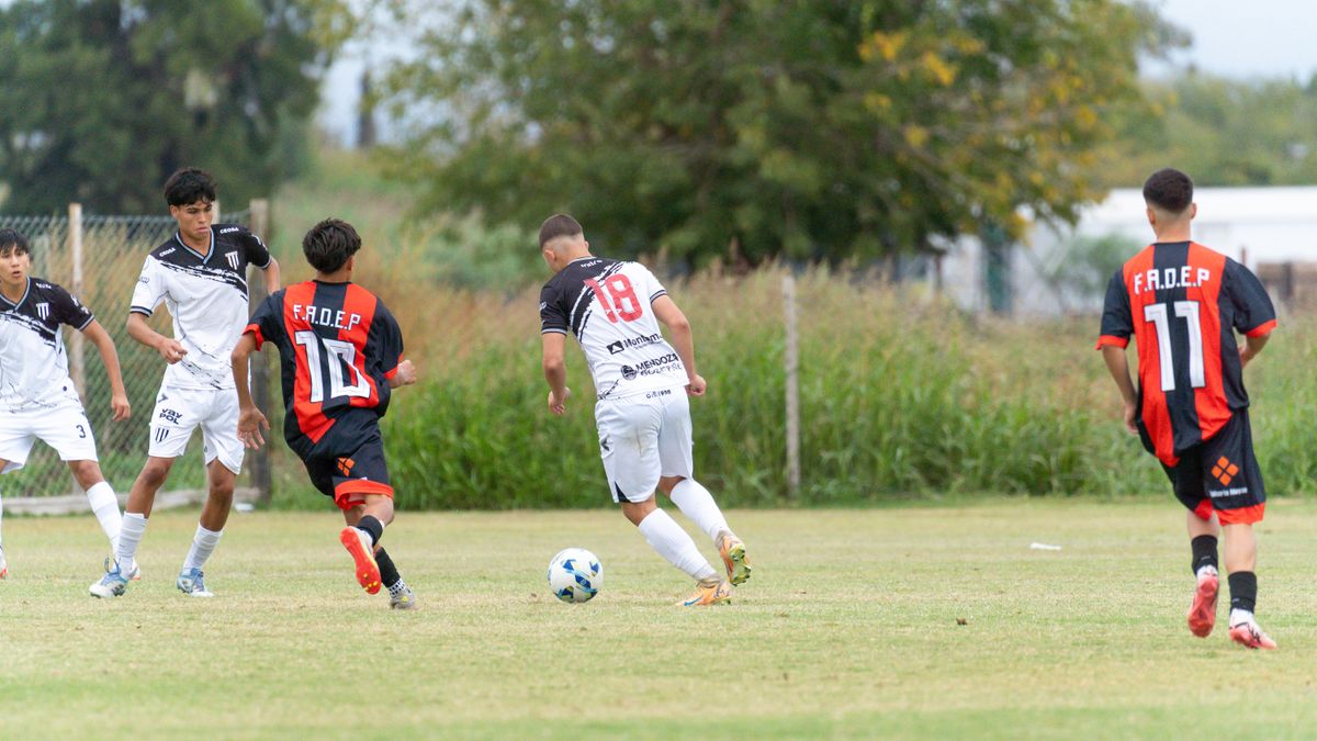 Competitive youth soccer match featuring players in action on an outdoor field.