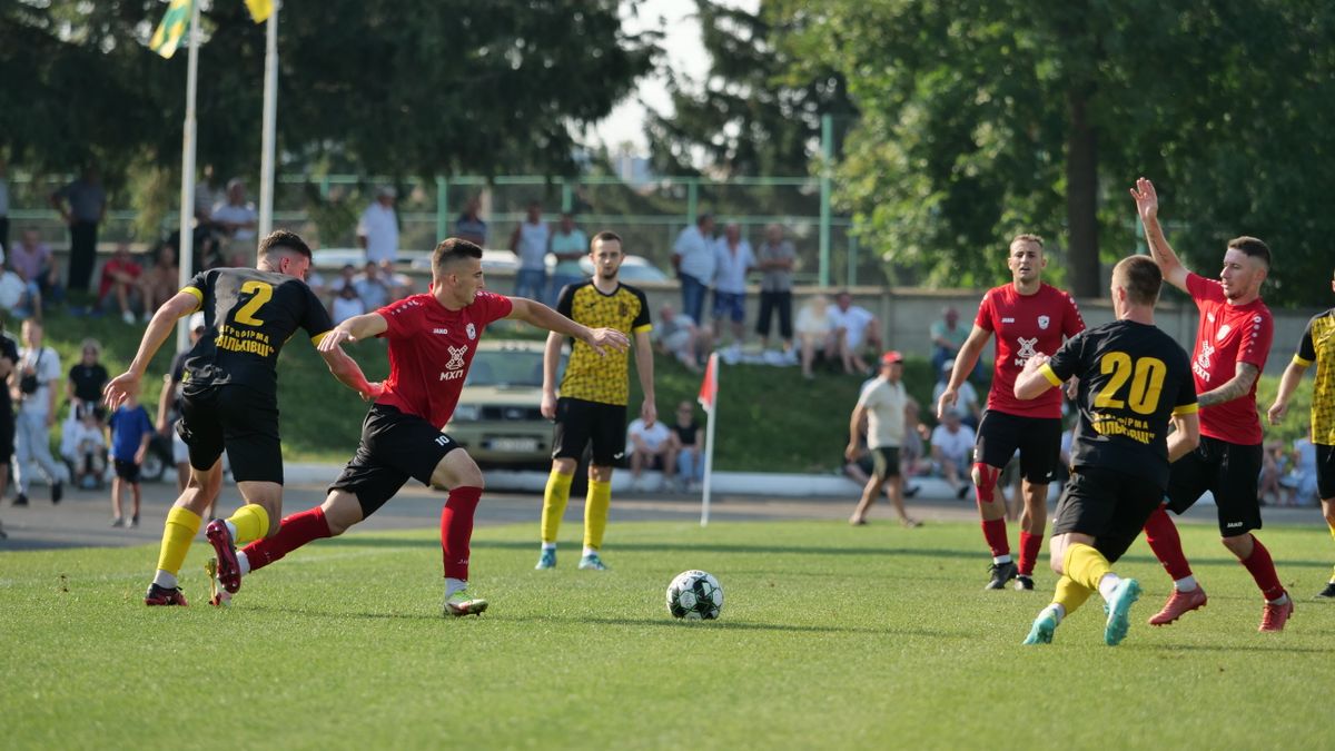 Dynamic action during a football match with teams in black and red jerseys. Dynamic action during a football match with teams in black and red jerseys.