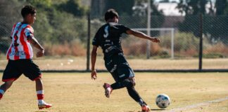 Dynamic football scene capturing two players in action during a match on a sunny field.
