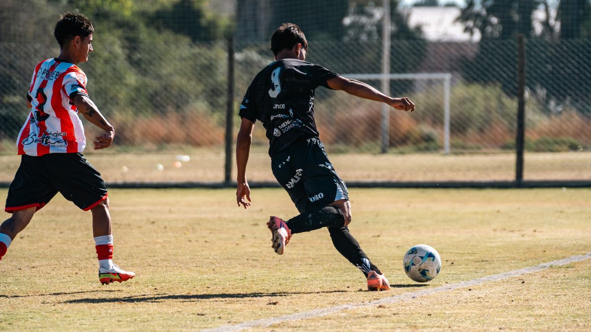 Dynamic football scene capturing two players in action during a match on a sunny field. Dynamic football scene capturing two players in action during a match on a sunny field.