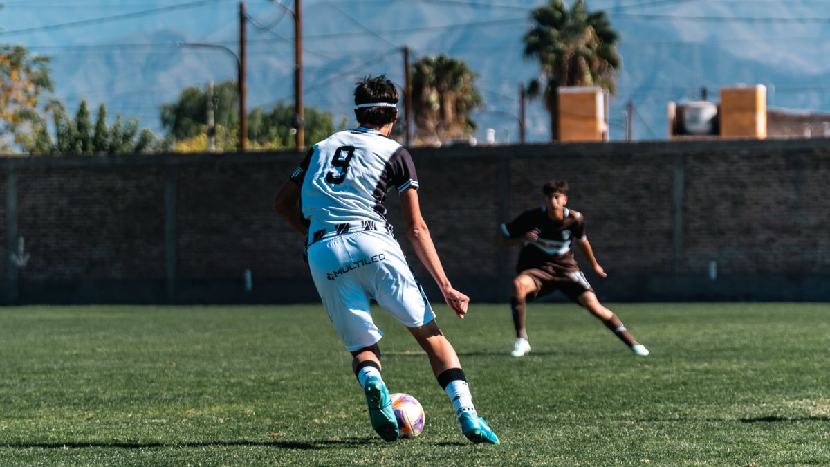 Dynamic image of two soccer players in action on the field under a clear sky. Dynamic image of two soccer players in action on the field under a clear sky.