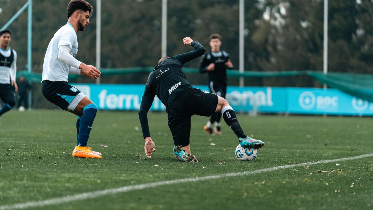 Dynamic shot of players competing fiercely on a soccer field during the day.