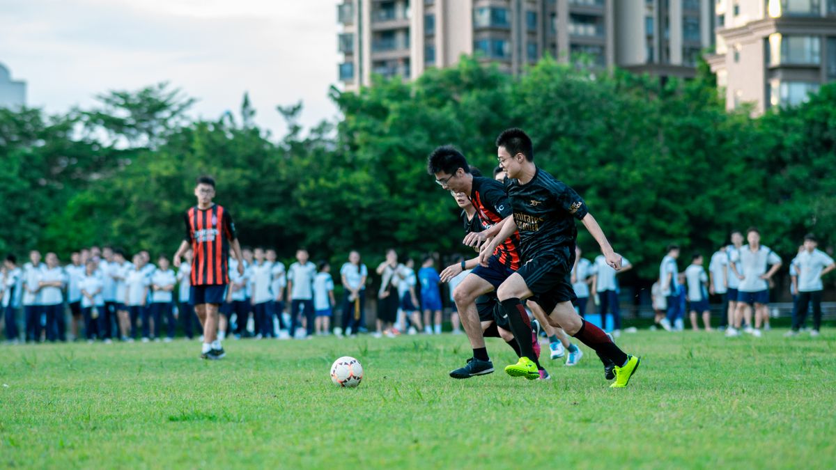 Dynamic soccer game capturing two young players in action on a grassy field surrounded by spectators. Dynamic soccer game capturing two young players in action on a grassy field surrounded by spectators.