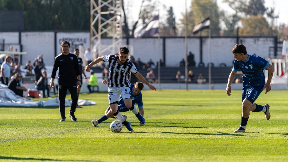 Players engaged in a competitive football game on a sunny day outdoors. Players engaged in a competitive football game on a sunny day outdoors.
