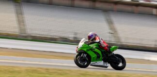 Professional motorcycle racer speeding at Hockenheimring in Germany. High-speed sports action captured outdoors.