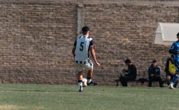 A team of young soccer players competing on an outdoor field, showcasing sportsmanship.