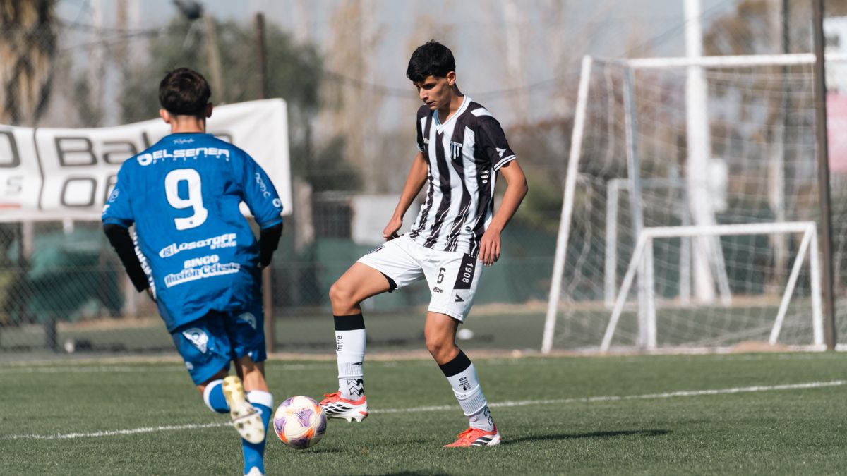 Two young players compete in a soccer match on a sunny day. Two young players compete in a soccer match on a sunny day.