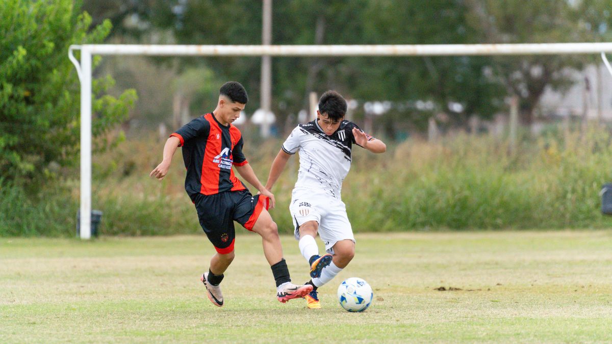 Two young soccer players in action on a grassy field during a competitive match. Two young soccer players in action on a grassy field during a competitive match.