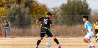 Two young soccer players in action on a sunny outdoor field during a casual game.